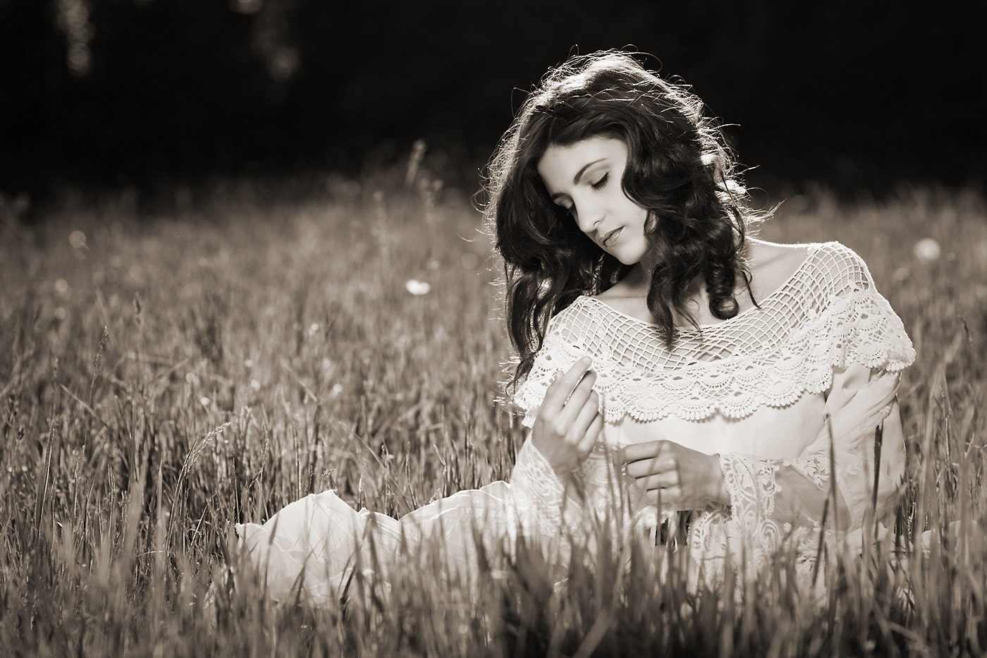 Image of a beautiful young woman sitting on a meadow