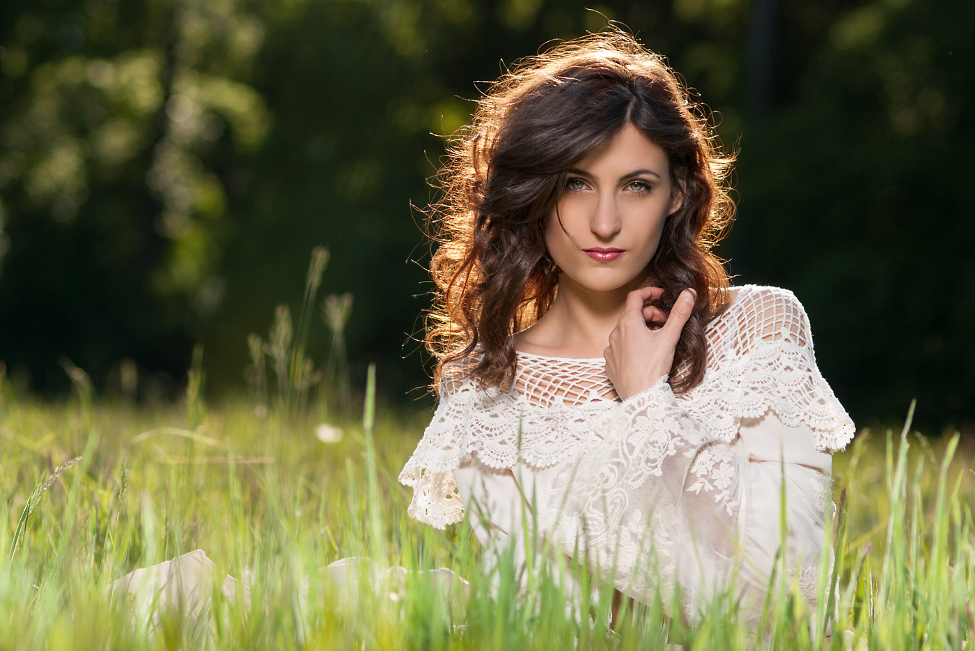 Image of a beautiful young woman sitting on a meadow
