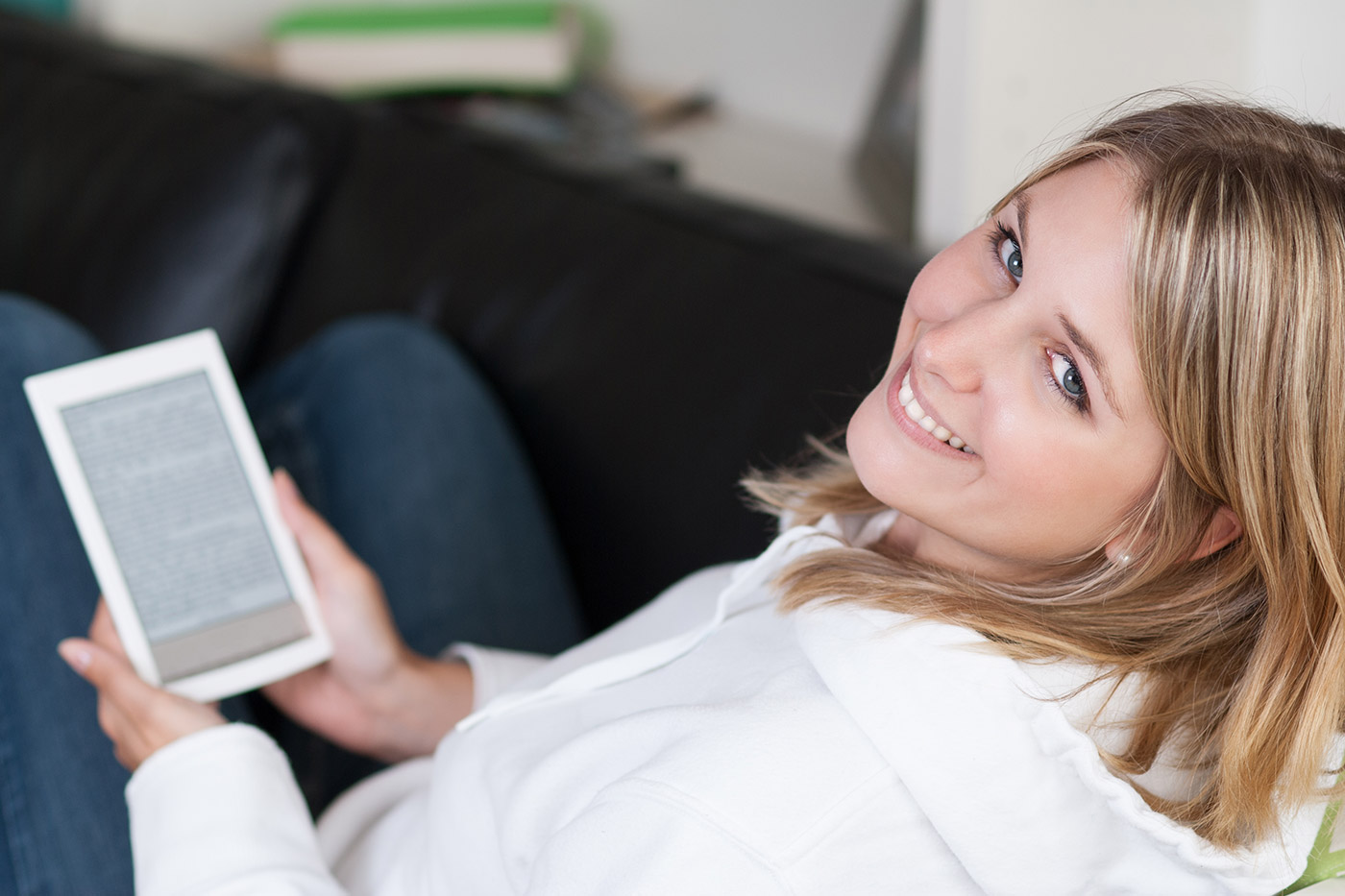 Stockfoto von einer Frau auf dem Sofa mit einem Ebook Reader